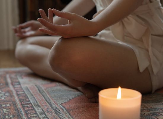 Woman in a peaceful yoga pose, surrounded by soft light.